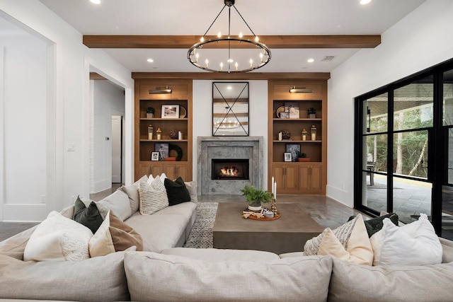 living room with beamed ceiling, built in shelves, a premium fireplace, and a chandelier