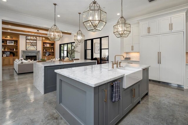 7010 Bowie Ct, Montgomery, TX 77316 - kitchen with gray cabinets, an island with sink, finished concrete floors, ornamental molding, and recessed lighting