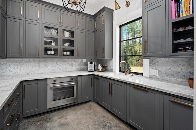 kitchen with oven, a healthy amount of sunlight, and gray cabinetry