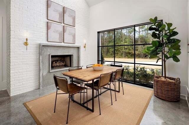 7010 Bowie Ct, Montgomery, TX 77316 - dining area featuring a fireplace, a towering ceiling, and finished concrete flooring