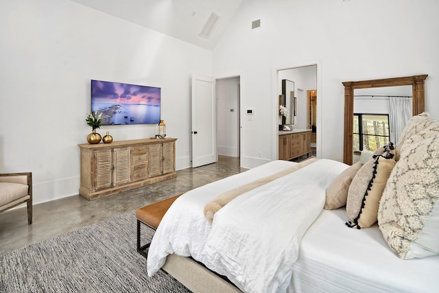 bedroom with ensuite bathroom, high vaulted ceiling, and concrete flooring