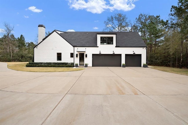 7010 Bowie Ct, Montgomery, TX 77316 - modern farmhouse style home with driveway, a chimney, and a garage