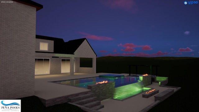 pool at dusk featuring an in ground hot tub, an outdoor fire pit, and a patio area