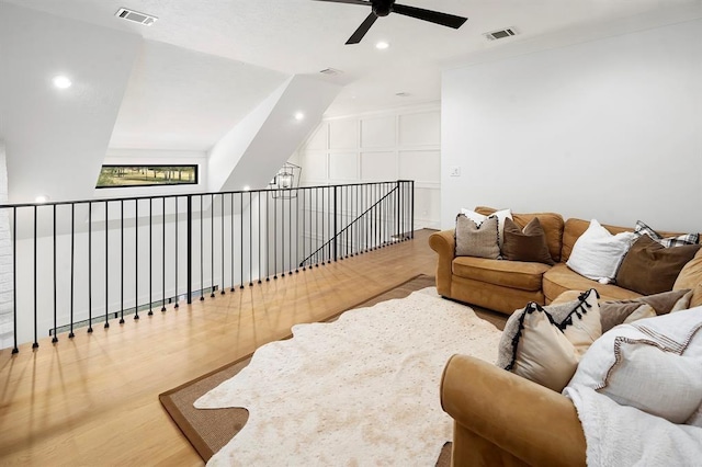 living room with hardwood / wood-style floors, ceiling fan, and lofted ceiling