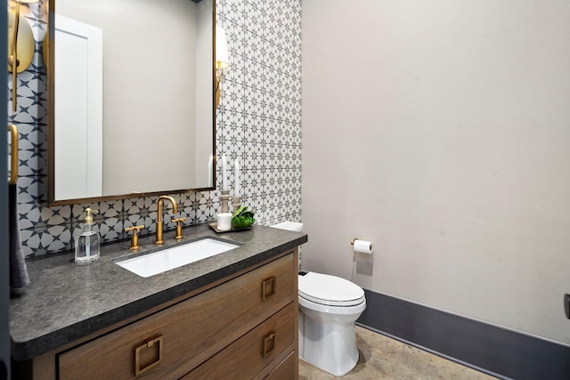 bathroom with vanity, toilet, and backsplash