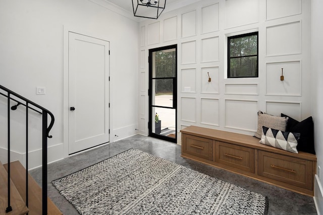 entrance foyer with ornamental molding and a notable chandelier