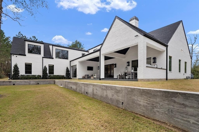 rear view of house featuring a yard