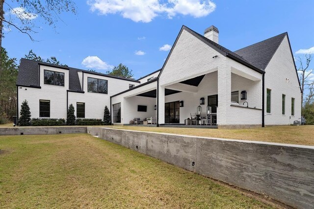 7010 Bowie Ct, Montgomery, TX 77316 - rear view of house featuring brick siding, a chimney, and a yard