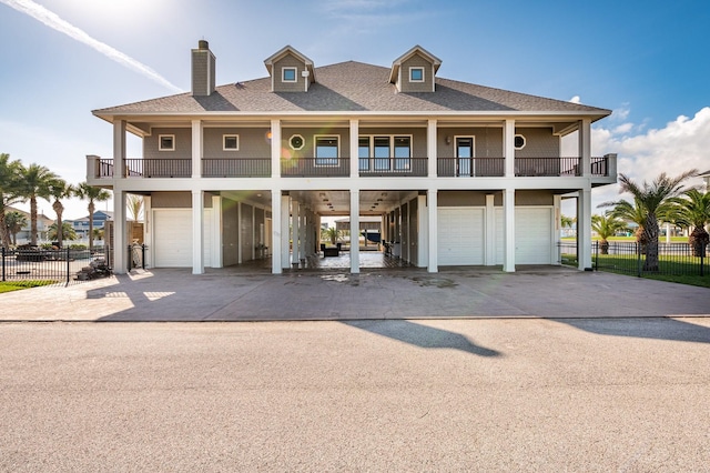 view of front of house featuring a carport, a garage, and a balcony