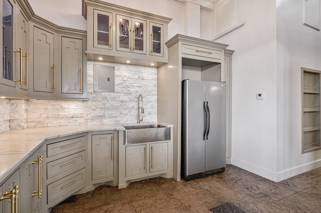1245 Lagoon Dr, Crystal Beach, TX 77650 - kitchen featuring light stone countertops, backsplash, gray cabinetry, sink, and stainless steel refrigerator