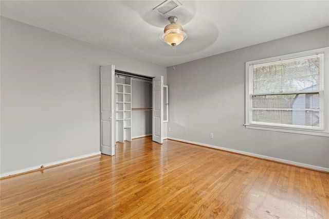 unfurnished bedroom featuring a closet, light hardwood / wood-style floors, and ceiling fan