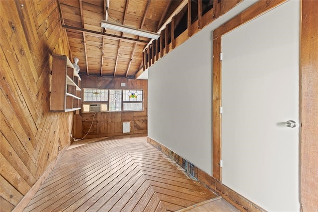 interior space with lofted ceiling, parquet flooring, wooden walls, and wooden ceiling