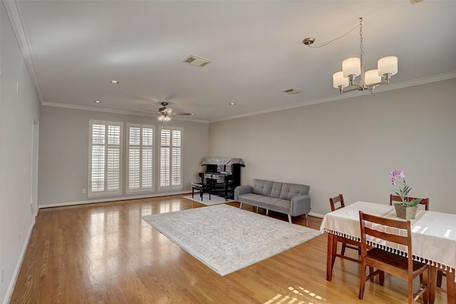 living room with crown molding, light hardwood / wood-style flooring, and ceiling fan with notable chandelier