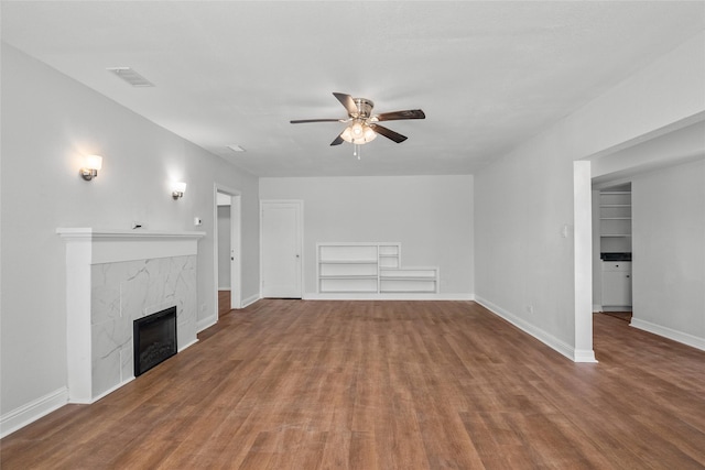 unfurnished living room with hardwood / wood-style flooring, ceiling fan, and a fireplace