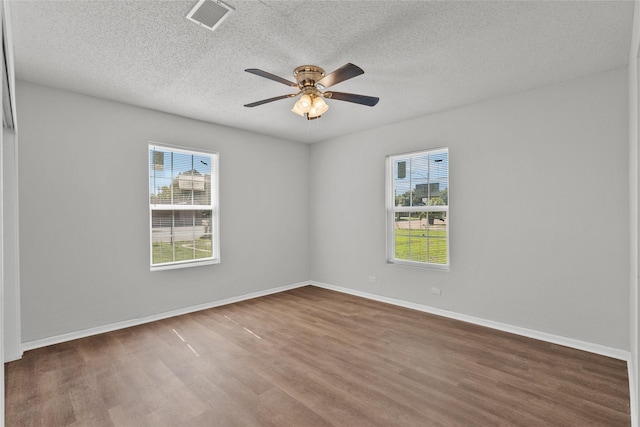 unfurnished room featuring ceiling fan, dark hardwood / wood-style flooring, and a textured ceiling