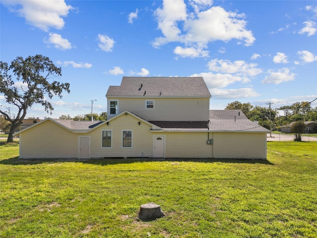 rear view of house featuring a yard