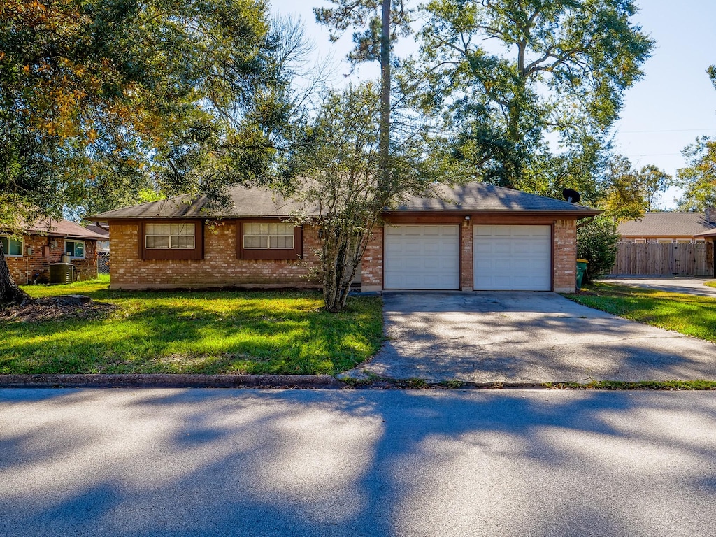 ranch-style home featuring a garage and a front lawn