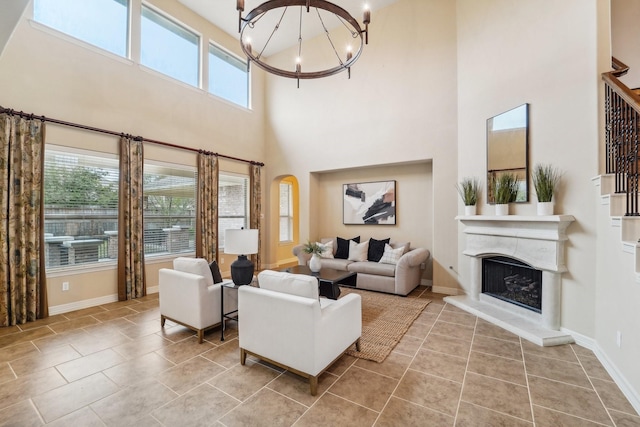 tiled living room featuring a high ceiling, a wealth of natural light, and a chandelier