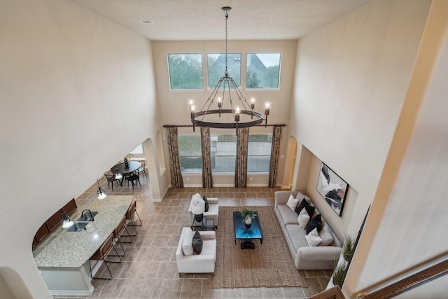 living room featuring a towering ceiling and a notable chandelier