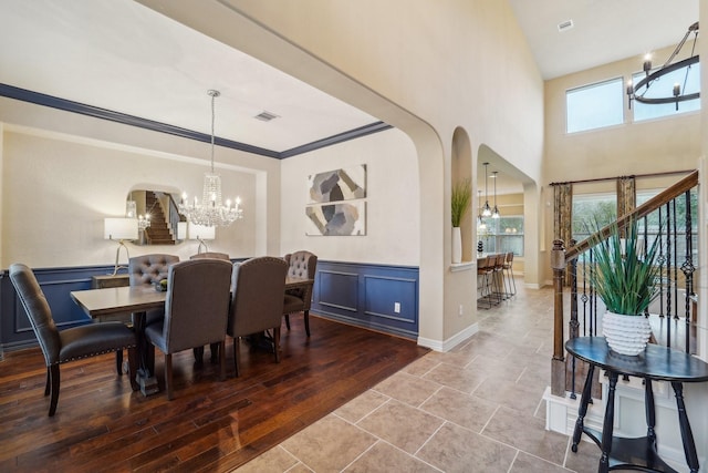 dining space with a chandelier, wood-type flooring, and ornamental molding