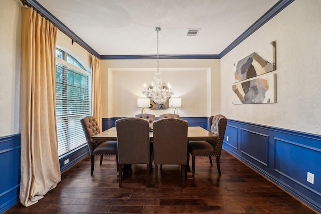 dining space featuring crown molding, dark wood-type flooring, and an inviting chandelier