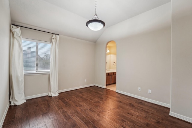 unfurnished room featuring vaulted ceiling and dark wood-type flooring