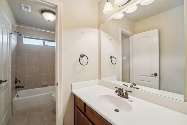 full bathroom featuring tile patterned floors, vanity, tiled shower / bath, and toilet