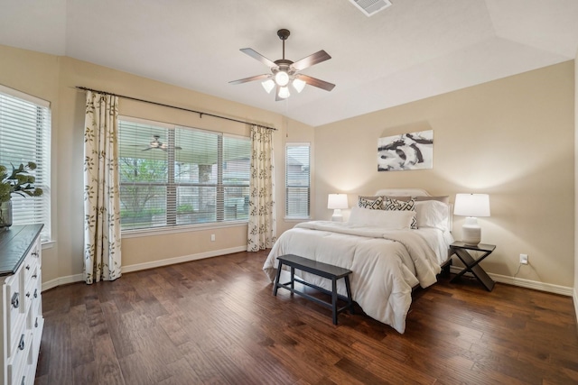 bedroom with dark hardwood / wood-style flooring, vaulted ceiling, and ceiling fan