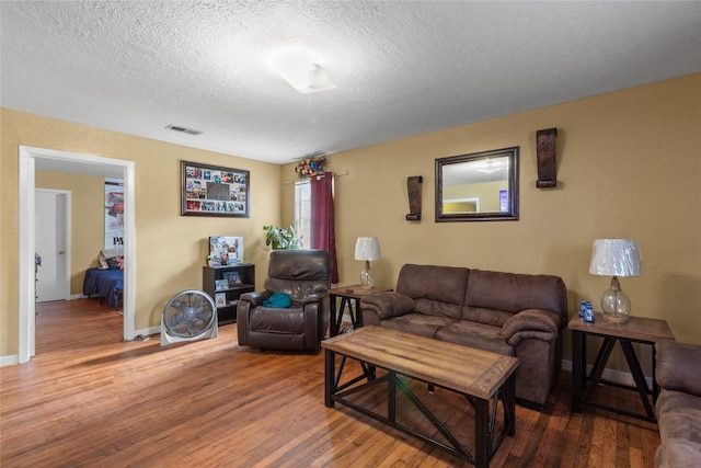 living room with a textured ceiling and hardwood / wood-style floors