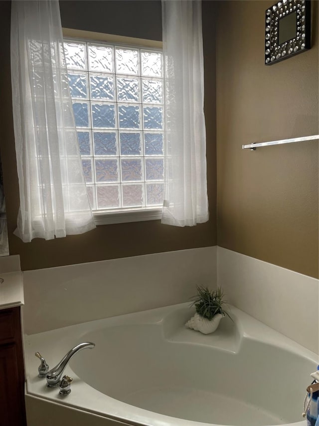 bathroom with a tub to relax in and vanity