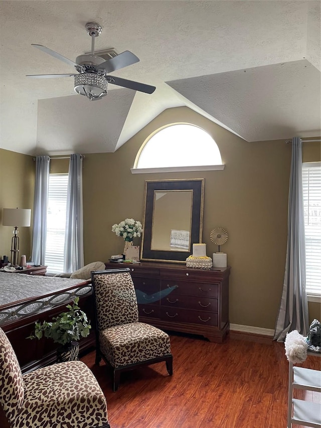 bedroom featuring ceiling fan, dark hardwood / wood-style floors, lofted ceiling, and multiple windows