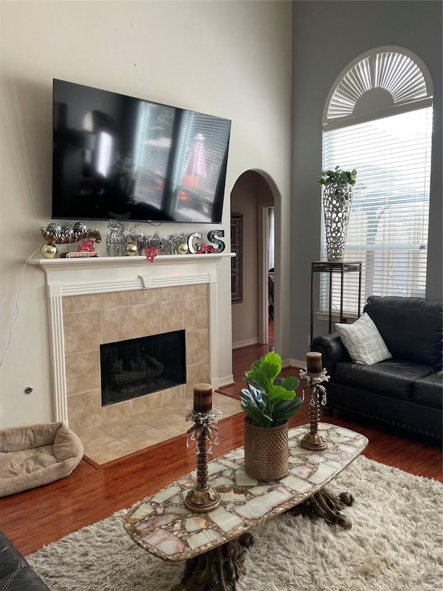 living room featuring hardwood / wood-style flooring and a tiled fireplace