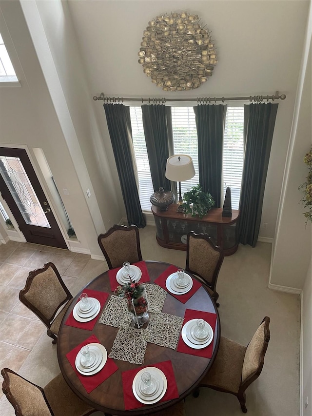 tiled dining area with a towering ceiling