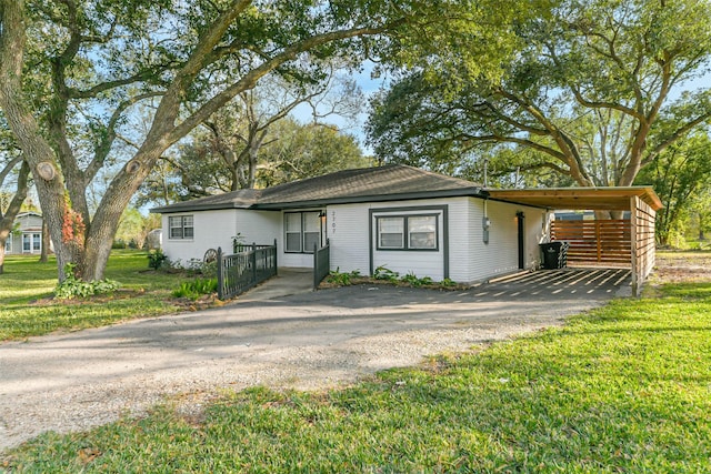 ranch-style house with a front yard and a carport