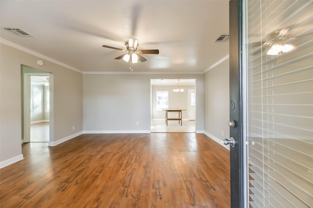 unfurnished living room with wood-type flooring, ceiling fan with notable chandelier, and ornamental molding