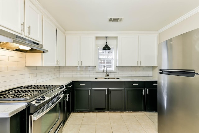 kitchen featuring sink, stainless steel appliances, light tile patterned floors, tasteful backsplash, and white cabinets