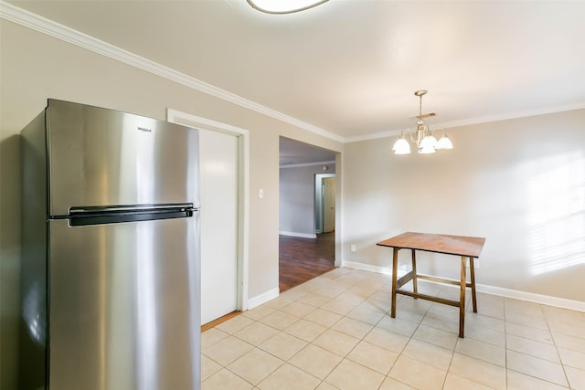 kitchen with stainless steel fridge, crown molding, light tile patterned floors, pendant lighting, and an inviting chandelier