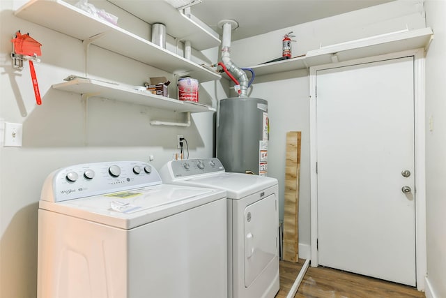 clothes washing area featuring water heater, washer and clothes dryer, and hardwood / wood-style flooring