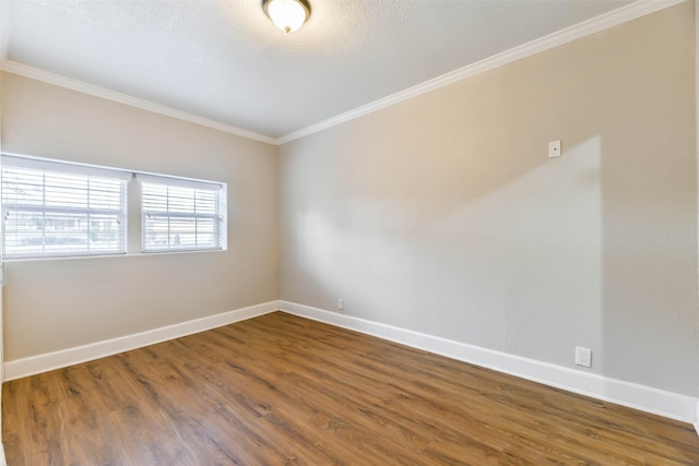 spare room with wood-type flooring and crown molding