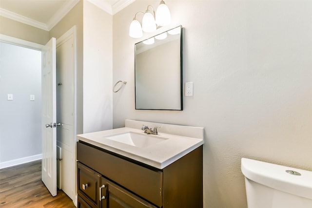 bathroom with hardwood / wood-style floors, vanity, toilet, and ornamental molding