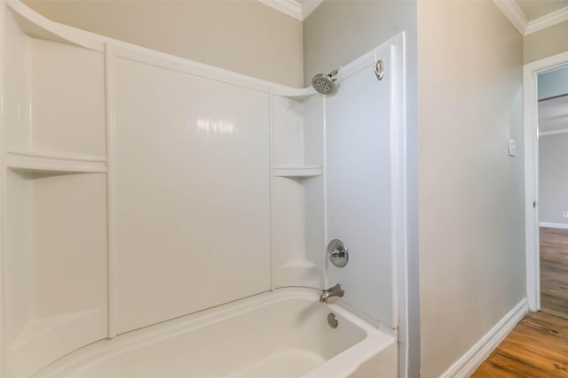 bathroom featuring wood-type flooring,  shower combination, and ornamental molding