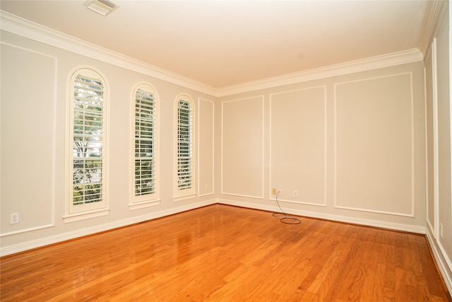 empty room featuring wood-type flooring and crown molding