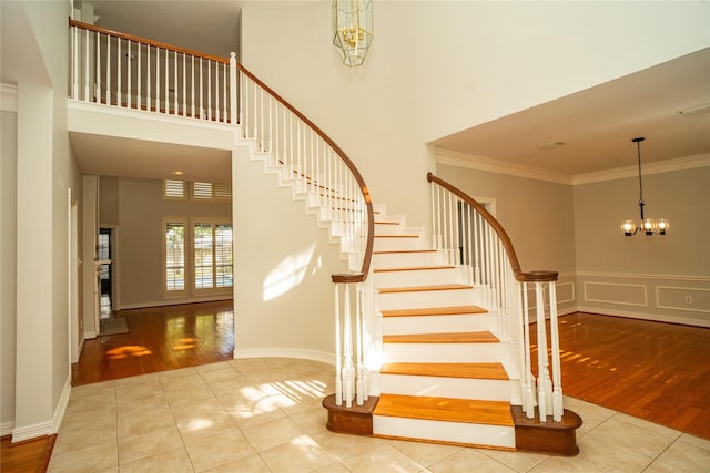 stairway featuring crown molding, a high ceiling, and hardwood / wood-style flooring