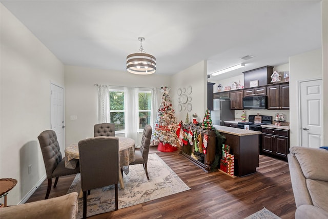 dining space with dark hardwood / wood-style floors and an inviting chandelier