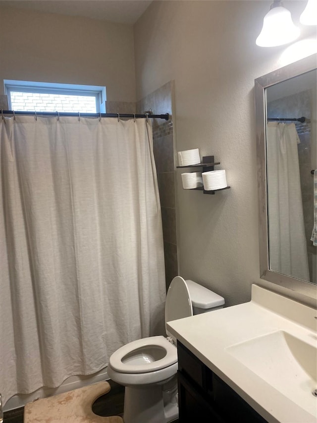 bathroom featuring vanity, toilet, and curtained shower