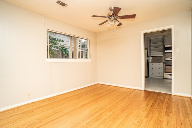 unfurnished bedroom with light hardwood / wood-style flooring, ceiling fan, and stainless steel refrigerator