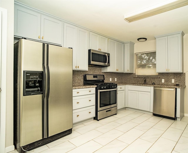 kitchen featuring backsplash, white cabinetry, and stainless steel appliances