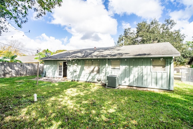 back of house featuring a yard and central AC unit