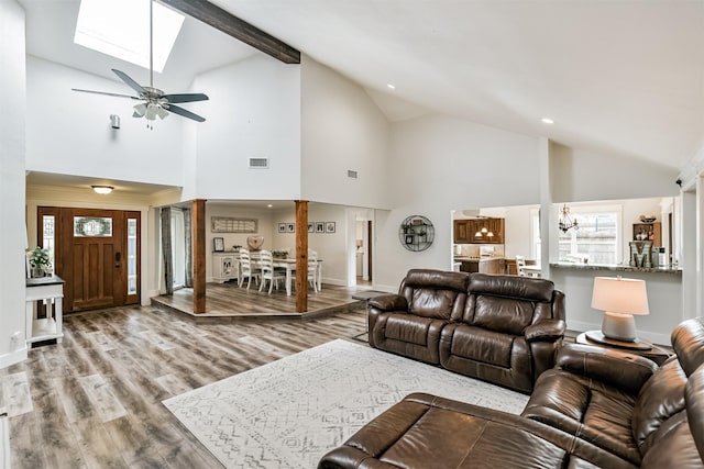 living room featuring hardwood / wood-style floors, ceiling fan with notable chandelier, high vaulted ceiling, and a wealth of natural light