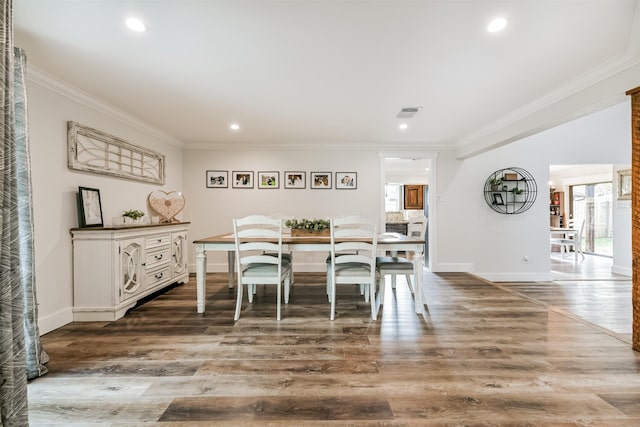 dining room featuring a healthy amount of sunlight, crown molding, and wood-type flooring